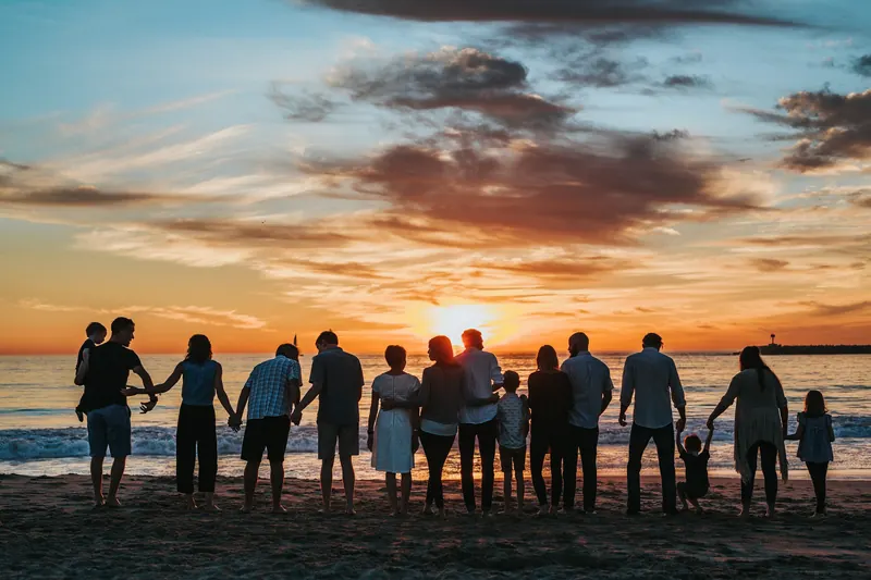 Family walking on the beach at dusk