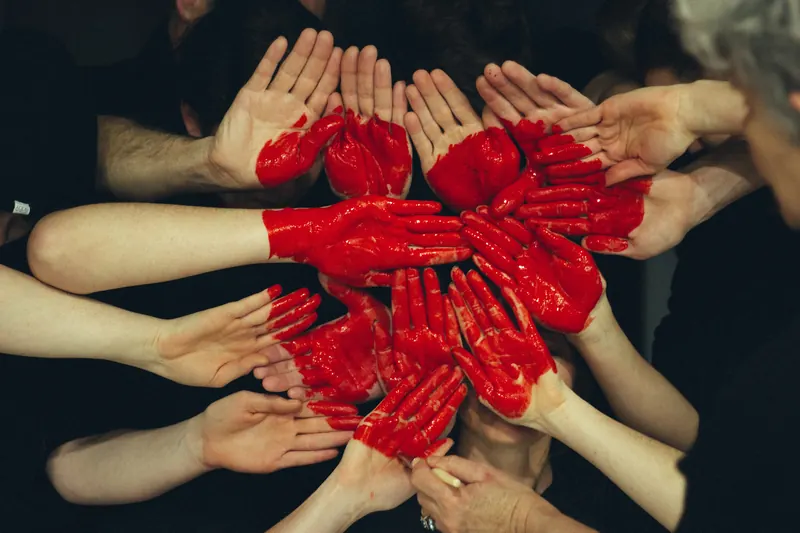 Many hands together holding a heart shape
