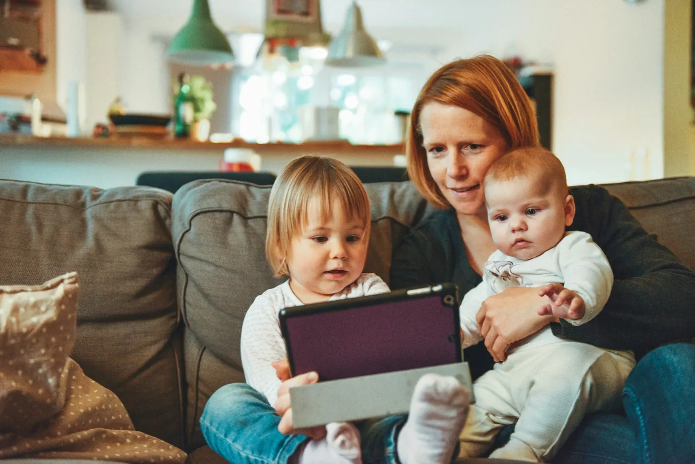 Mother reading with her children at home