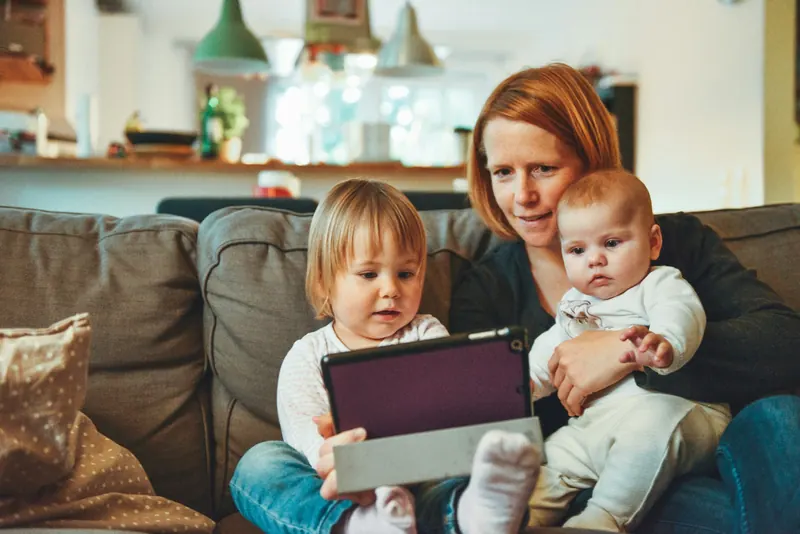 Mother relaxing on the couch with her two children