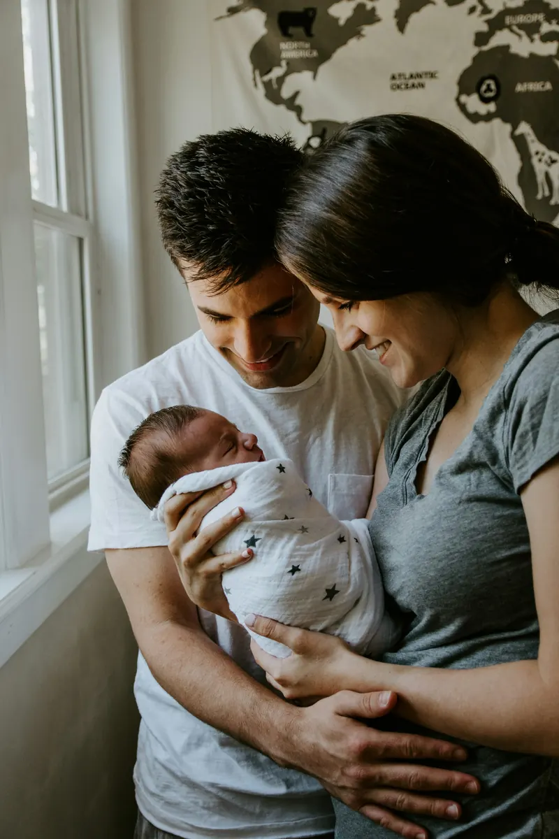 New parents holding their sleeping newborn